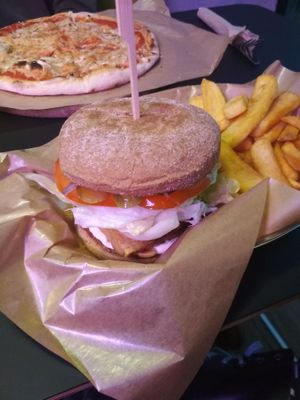 Burger with tempeh, fries, and vegan pizza at Green Bus in Wroclaw