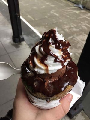 dough my goodness. scoops of ice cream in a donut cone with whipped cream and sauce at Sweet Release in Wellington