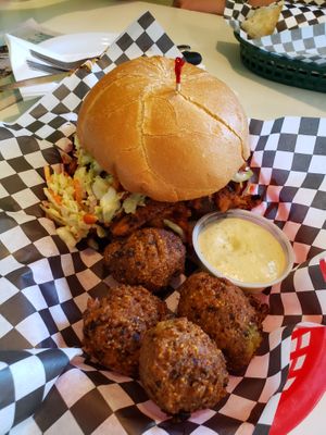 SloSmoMoFo sandwich with smoked soy curls, BBQ sauce, pickles, and coleslaw with a side of hush puppies and remoulade. Photo taken May 2019. at Homegrown Smoker in Portland