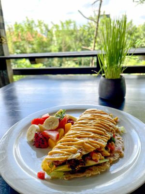 Avocado Omelet – a magical, plant-based, egg-free omelet filled with creamy avocado, baked sweet potatoes, and slices of fresh tomato. at Moksa in Ubud