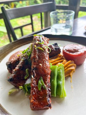 Tempeh Ribs – grilled soy tempeh marinated in a homemade BBQ sauce, served with mashed sweet potatoes, steamed green beans, and a grilled tomato. at Moksa in Ubud