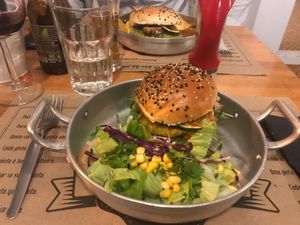 Veggie burger with sauté mushroom, courgette and crispy onion in homemade bread bun and salad. at Com Pinta in Ericeira