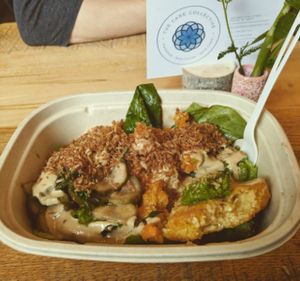 Mixed greens, sweets/turnips, grit cake, housemade pickles drizzled with tahini and topped with onion coconut. Simply delicious! at Kindly Kitchen in Boone