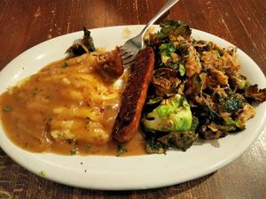 Oktoberfest Plate. Oven roasted Beyond sausage, served with mashed potato, sauerkraut and brussel sprouts. Topped with onion gravy. at Veg Cafe in Sacramento
