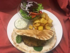 Vegan Greek Burger served with Roasted Potatoes fresh salad and Flatbread and topped with Vegan Tzatziki. One of our popular Vegan Burgers! at Eat at Jo's in Amsterdam