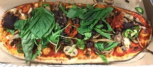 Vegan pizza with vegan cheese & vegan beef, chickpeas, jalapeños, mushrooms, grilled onions, sun-dried tomatoes, arugula and fresh basil  at IAD - &pizza - CC in Dulles
