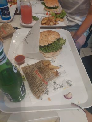 Burger in a wholegrain bun plus wedges in a menu at Krowarzywa in Krakow