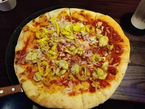 thin crust pizza with vegan marinara, vegan mozzarella, tempeh, banana peppers, roasted yellow squash, red onion at Blue Highway Pizza in Ocala