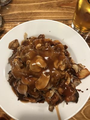 Poutine with crushed potatoes, vegan cheese, onions, mushrooms, and poutine sauce at Poutineville in Quebec