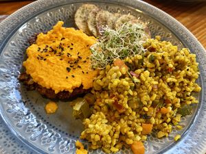 Hamburger with carrot cream, brown Yamani rice, and potatoes  at Curcuma in El Chalten
