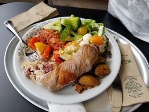 My friend's dinner - whole wheat roll, broccoli, cheese balls, potatoes, tomatoes, eggplant parmesan, strawberry rhubarb dessert... at Hiltl - Dachterrasse in Zurich