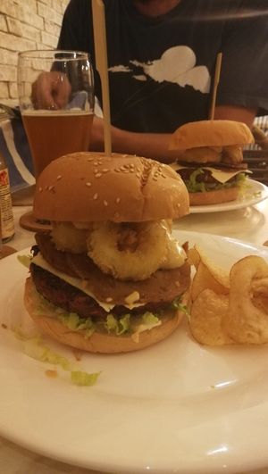 Burger with cheese, bacon and onion rings. at Green Bar in Makati
