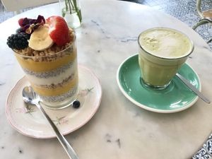 Vegan mango/lime ‘triffle’ layered with fruit, soya yogurt, chia pudding and cashew/coconut granola, topped with fruit and flowers. With matcha latte    at By Lima in Haarlem