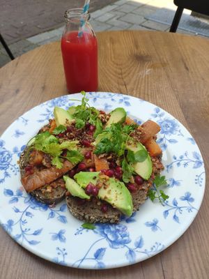 Muhammara bread with paprika, walnut, pomogranate, roasted cumin carrots and avocado. Also pictured is the slow juice with pineapple, watermelon and lemon crest at By Lima in Haarlem