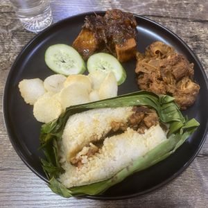 A weekly special: Vegan nasi bakar with stir-fried tempeh, jackfruit curry, tofu sambal, veg keropok and cucumber.  at The Black Cat Cafe in Kuala Lumpur