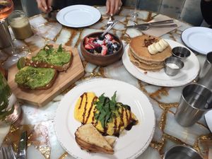 Brunch - avocado toast, coconut yoghurt fruit bowl, vegan pancakes, turmeric latte (ignore the omelette at the front which isn't vegan) at The Butcher's Daughter in Venice