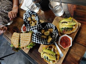 Bagelwich and lentil Patty sandwich with home fries at The Pitted Date in Playa Del Carmen