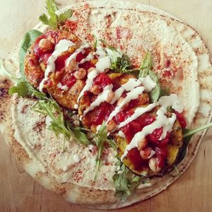 Aubergine fritters with smokey chickpeas, tahini, harissa houmous, salad and flatbread at Numinums in Nottingham