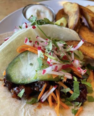 Korean BBQ Mock Duck Tacos with a side of potato wedges   at Reverie Cafe + Bar in Minneapolis