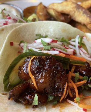 Korean BBQ Mock Duck tacos with a side of potato wedges.  at Reverie Cafe + Bar in Minneapolis