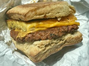 Yummy Biscuit sandwich: Housemade Biscuit, Housemade Sausage, Just Egg Patty, Cheese, Garlic Aioli (Contains Tree Nuts) 💚  at Reverie Cafe + Bar in Minneapolis