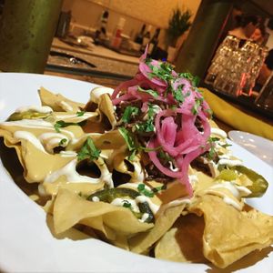 Supreme Nachos with housemade nacho cheese, pickled jañepeno, pickled onion, Limeleaf sour cream & smoked jackfruit. at Reverie Cafe + Bar in Minneapolis