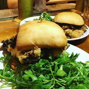 (Front) Fried Cauliflower Po Boy with smokey cashew remodelade, arugula and (Back) Berbere BBQ Sammie with housemade seitan, peppers, onions & garlic aioli. at Reverie Cafe + Bar in Minneapolis