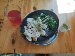 small plate of batata (sweet potato) with cashew lebaneh, tabuleh and tofu. on the left there's hybiscus lemonade and on the right there's a shot of green soup made of mangold at Herzog in Tel Aviv