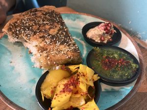 Homemade bread with zattar and dip, babaganoush and pickles. The green dip was amazing.  at Kanaan in Berlin