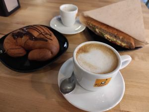 Croissant with chocolate, cappuccino, esspreso and foccacia with chickpeas cream and arugula. at Canape Incontro in Bologna