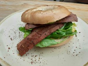 Facon bagel with roasted cherry tomatoes, spinach and salsa verde at Hyde Park Book Club in Leeds