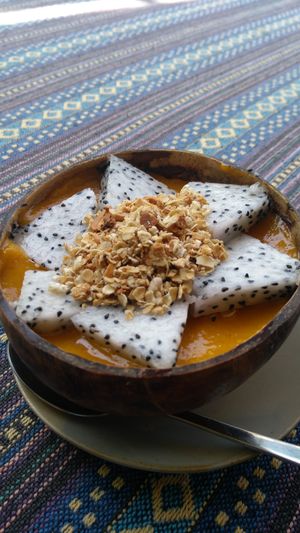 Orange smoothie bowl: iced pumpkin and tropical fruits, topped with granola (with peanuts) and dragonfruit at Nomad Cafe in Hoi An