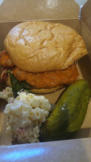 buffalo chicken sandwich with bacon macaroni salad and a pickle at The Butcher's Son in Berkeley