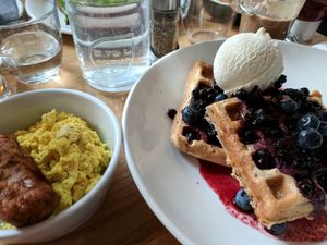 The vegan quinoa oat and blueberry waffles with maple syrup and ice cream, "sausage," and tofu scramble. at Mildreds - Kings Cross in North London