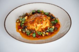Raviolone with ricotta and spinach, in a Mediterranean sauce with capers and olives. at MADENITALY in Copenhagen