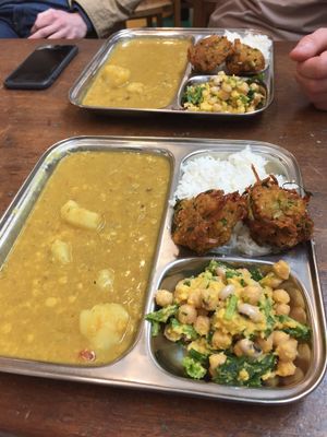 Vegetable dahl, rice, onion bhajis and a cold chickpea salad at Thenga Cafe in London