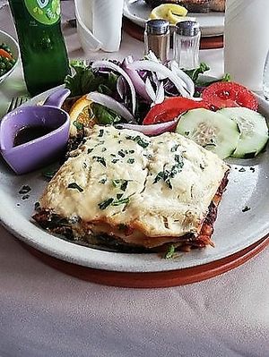 Our veggie lasagne packed with spinach, tomato, & ricotta. Served with "fresh" cut salad, tangy baslamic vinegarette, & homemade chunky chips.  at O Forno in Calheta