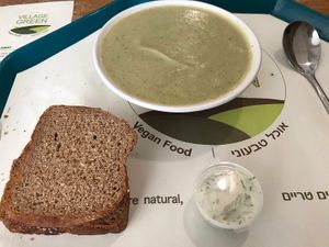 Tasty and healthy broccoli and spinach soup, big portions with 2 slices of variety of breads. at Village Green in Jerusalem