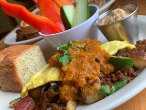 El Sol Omelette: Vegan Egg,  Vegan Chorizo, Vegan Provolone, Sautéed Onions, Potatoes, Zucchini, Cilantro, Salsa Roja, choice of side (Veggie Sticks & Hummus) & Toast (Lemon Poppyseed Bread) (Kalamazoo Vegan Chef Challenge 5/26) at Crow's Nest in Kalamazoo
