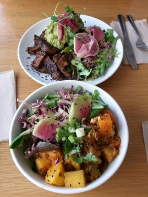Curry bowl (bottom) and burger with guac, yam fries, and salad. Delicious. at Kupfert & Kim - Spadina in Toronto