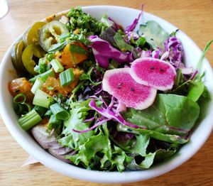 Curry bowl...Tofu, onion, tomato, pineapple, zucchini, carrots, and yam in a spicy red curry sauce on brown rice, with side salad and pickled jalapeno peppers. at Kupfert & Kim - Spadina in Toronto