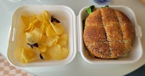 Gardener burger with poppy seed bun and chips at Caju in Nice