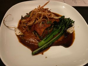 Lasagna with apple wood smoked tomato sauce, garlic herbed cashew cheese, braised greens, and roasted chanterelle mushrooms topped with fried parsnip chips, and balsamic reduction at Harvest Beat in Seattle