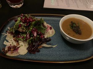 Wild mushroom bisque with onions alongside greens with candied pecans, oranges, pomegranate seeds, herbed roasted beets, and shaved radish in creamy tarragon dressing at Harvest Beat in Seattle