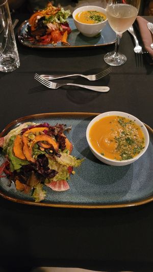 pumpkin-ginger soup topped with a fried garlic gremolata alongside baby lettuces with cara-cara oranges, baby beets, a fennel-radish slaw, house made almond ricotta, pistachios wit at Harvest Beat in Seattle