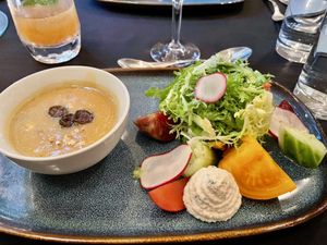 Sweet com chowder and baby lettuce and frisee salad with heirloom tomato, local cucumbers, almond ricotta, and roasted costata squash in a lemon dill vinaigrette.  at Harvest Beat in Seattle