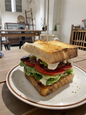 Must order avo sandwich with tempeh, vegan cream cheese, tomato and greens - sourdough or bagel 65k  at La Studio in Hanoi