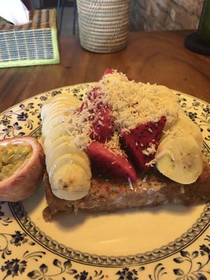 Vegan French toast with bananas, passion fruit and dragon fruit. Topped with coconut shavings.  at Simple Things in Kampot