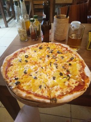 Pizza with pineapple and olives toppings. Nice dressings on the side. at Simple Things in Kampot