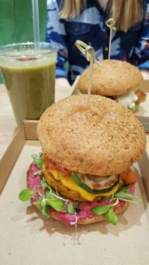 sweet potato burger, with bbq tofu burger behind and green smoothie at Vegan Love in Budapest